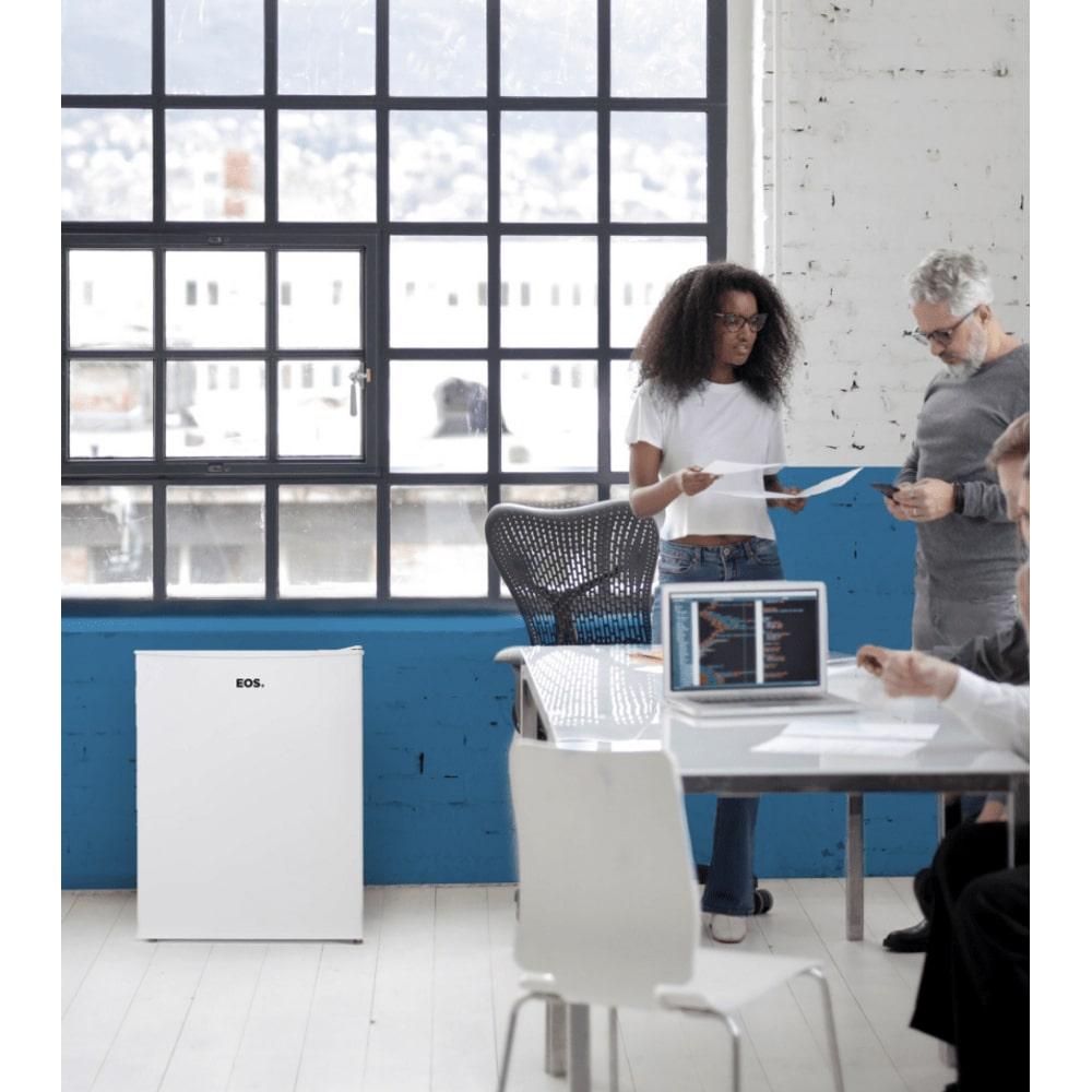 Frigobar Mini Refrigerador EOS Ice Compact 47L branco em sala de reunião, perfeito para manter bebidas e lanches acessíveis durante encontros.