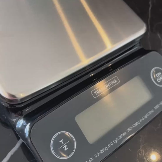 Vídeo de anúncio da balança digital de alta precisão para cozinha Tramontina, com capacidade de 3kg. Ideal para quem busca medições exatas de ingredientes secos e líquidos em receitas, com resultados confiáveis. O produto possui acabamento em inox, perfeito para uso doméstico ou profissional. Disponível na Salvador Comercial.