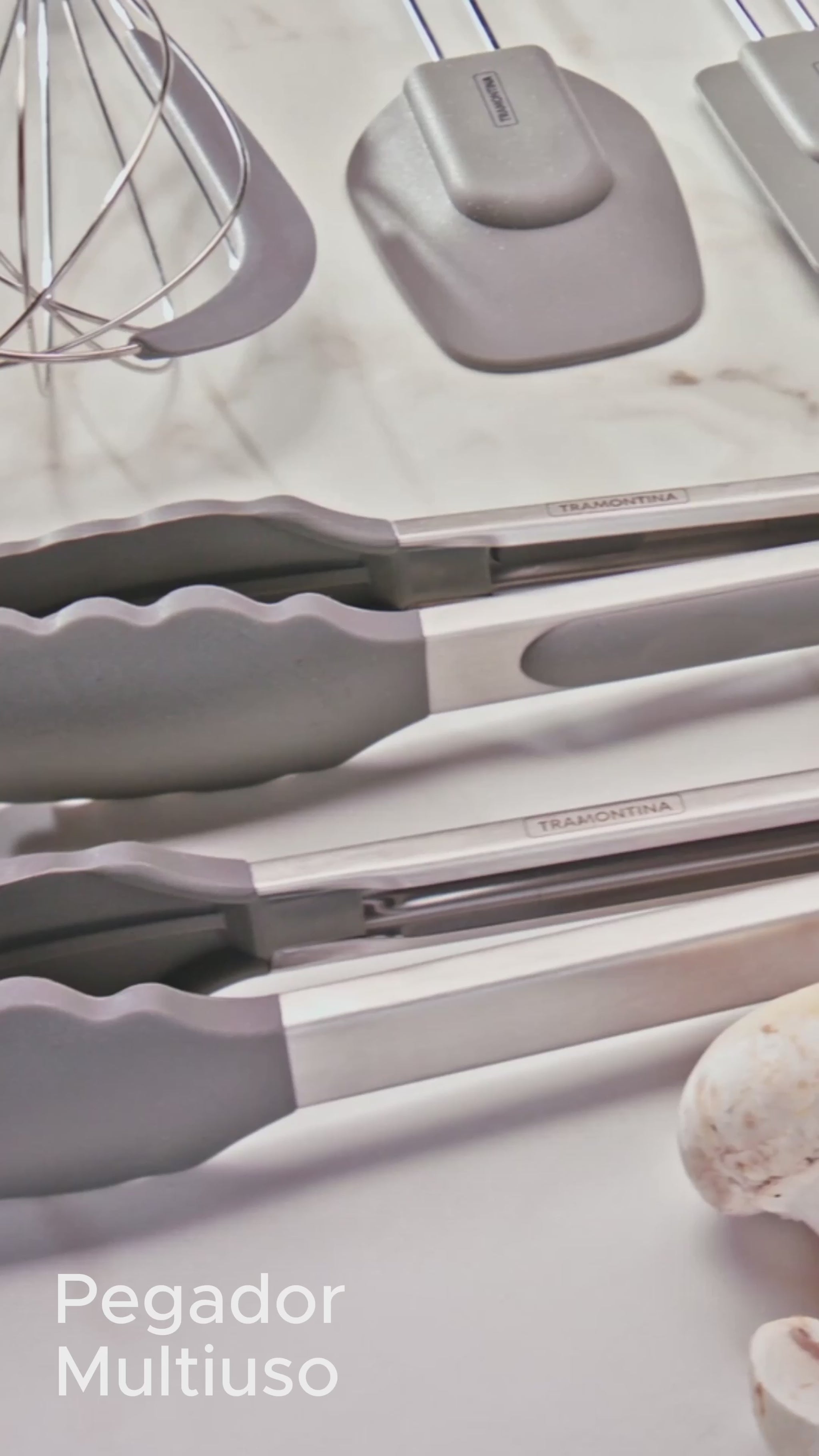 Anúncio em vídeo do pegador de silicone Tramontina. Utensílio de cozinha de alta qualidade para manusear alimentos quentes com segurança. Design em aço inox e silicone cinza, ideal para panelas e frigideiras antiaderentes. Compre na Salvador Comercial.