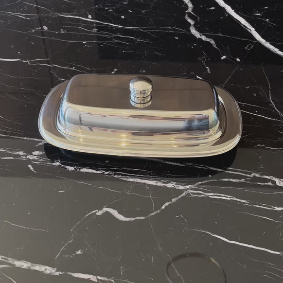 Vídeo de anúncio da manteigueira Tramontina Service, feita em aço inox. O produto retangular com tampa é ideal para armazenar manteiga de forma higiênica e elegante, seja para uso doméstico ou profissional. Encontre a manteigueira de inox na Salvador Comercial.